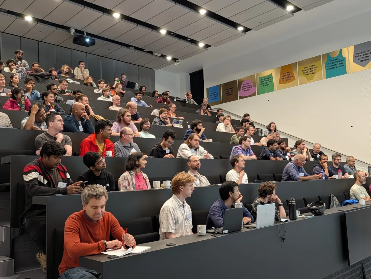 WACT participants listening to a talk in a tiered lecture hall.