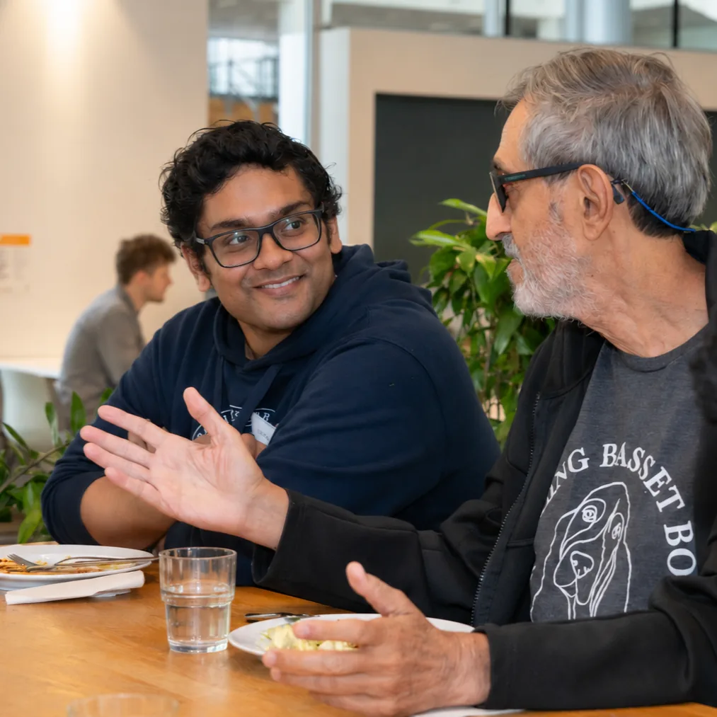 Prateek Dwivedi and Avi Wigderson talking over a meal at WACT 2026.